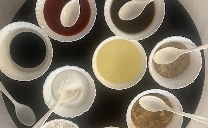 Top view of assorted condiments and spices in small white bowls