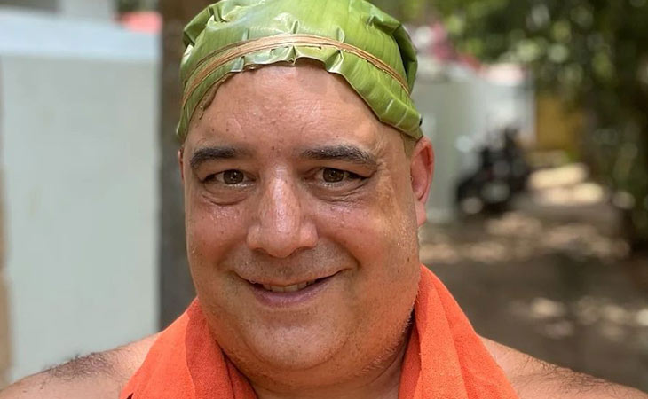 Man wearing a head covering made of green leaves